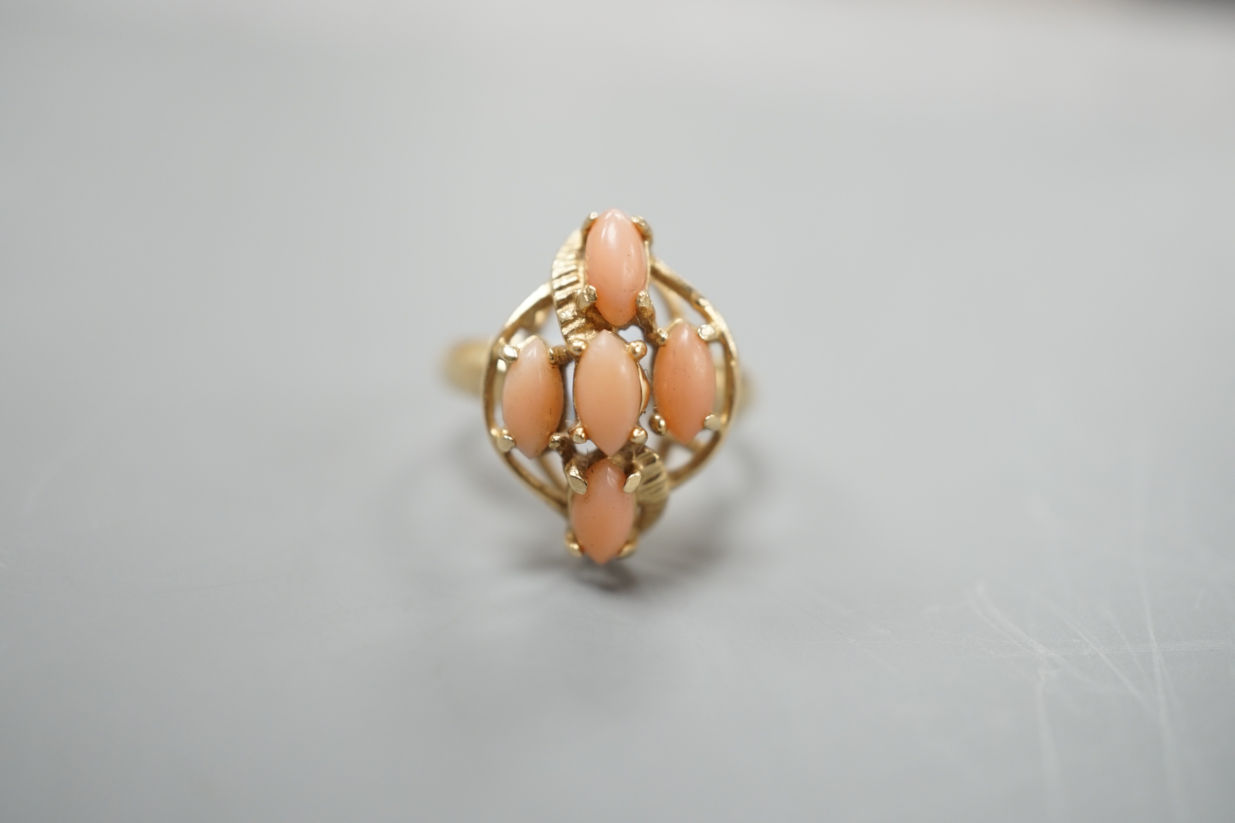 A modern 14k yellow metal and five stone oval coral bead set dress ring, size J/K, gross weight 2.9 grams.